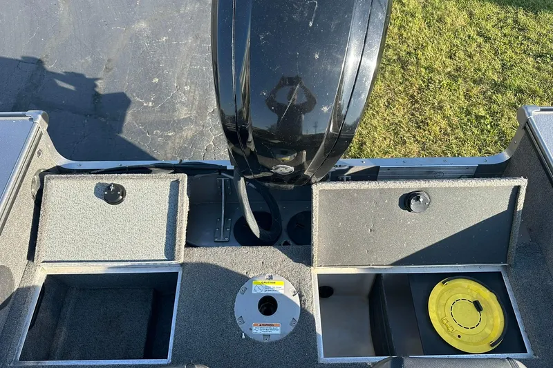 Slide: The Image of 2016 Lund 1775 Pro-V SS boat interior with open storage compartments and motor. - 20