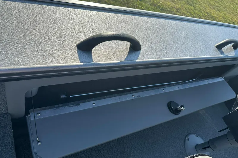 Slide: The Image of 2016 Lund 1775 Pro-V SS boat interior storage compartment with handle and lock. - 21