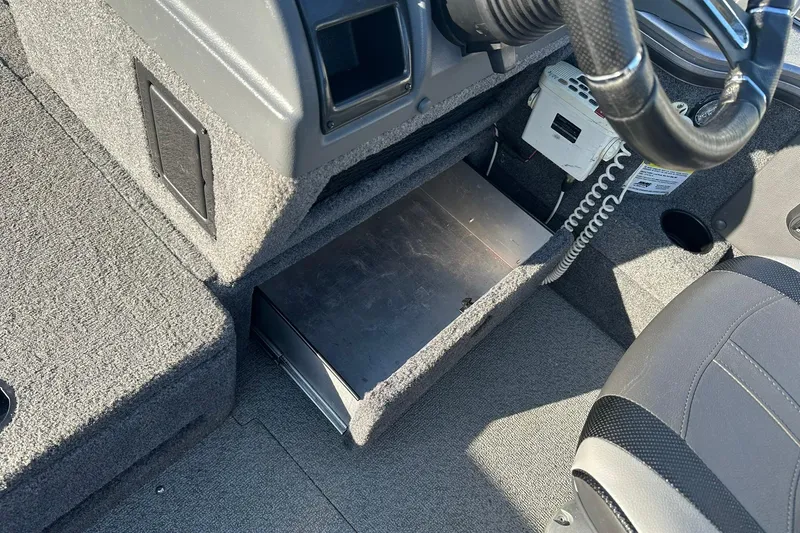 Slide: The Image of Interior of 2016 Lund 1775 Pro-V SS boat showing steering wheel and storage compartment. - 22