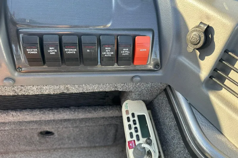 Slide: The Image of Control panel of a 2016 Lund 1775 Pro-V SS boat with switches and a 12V outlet. - 24