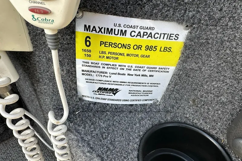 Slide: The Image of U.S. Coast Guard capacity label on 2016 Lund 1775 Pro-V SS boat, showing weight and person limits. - 33