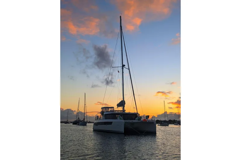 Slide: The Image of 2023 Leopard 42 catamaran at sunset, anchored in a tranquil harbor. - 15