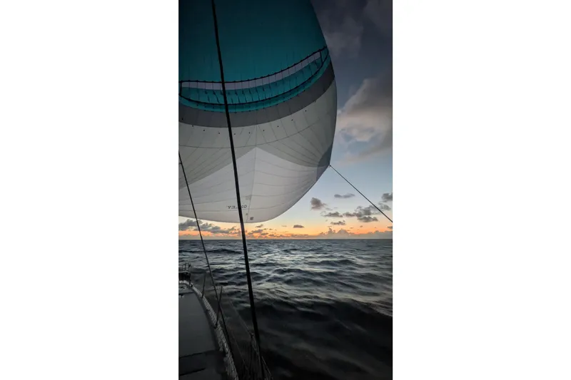 Slide: The Image of Sailing at sunset on a 2023 Leopard 42 catamaran, vibrant spinnaker against ocean waves. - 18