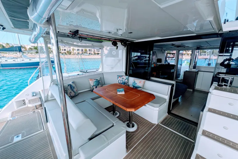 Slide: The Image of Luxurious 2023 Leopard 42 yacht interior with elegant seating and wooden table, docked by the sea. - 25