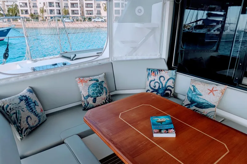 Slide: The Image of Luxurious 2023 Leopard 42 yacht interior with nautical-themed cushions and a wooden table. - 29