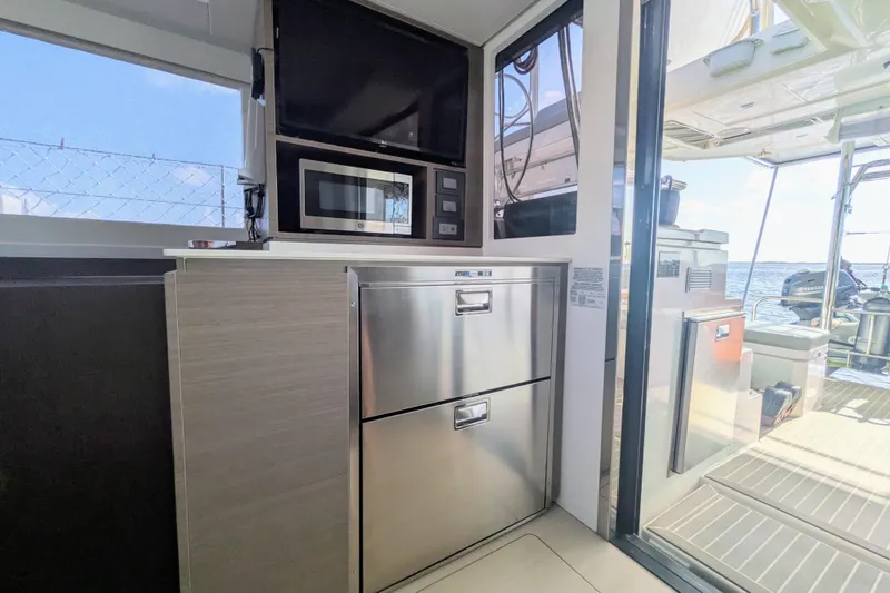 Slide: The Image of Modern kitchen area on a 2023 Leopard 42 yacht with microwave and stainless steel appliances. - 56