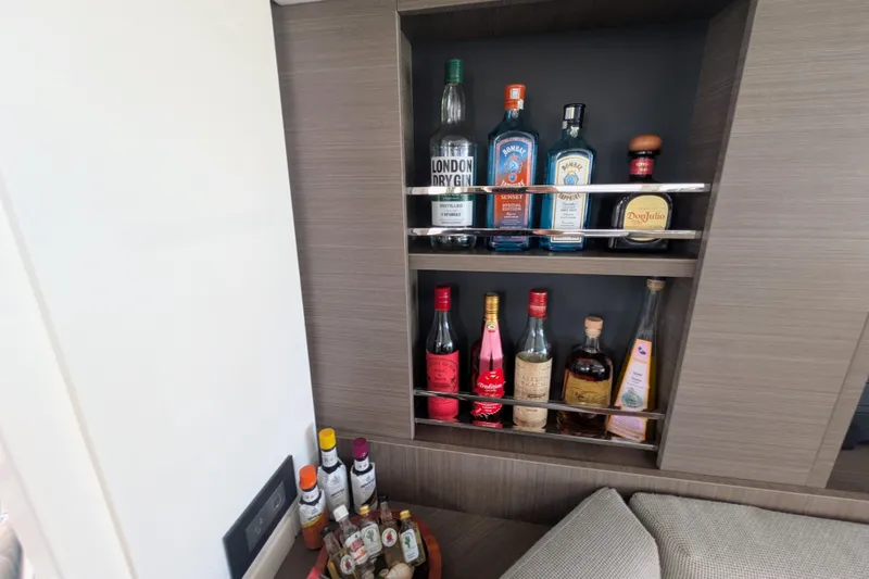 Slide: The Image of Bar area on Leopard 42 yacht, showcasing assorted liquor bottles in a modern wooden cabinet. - 58