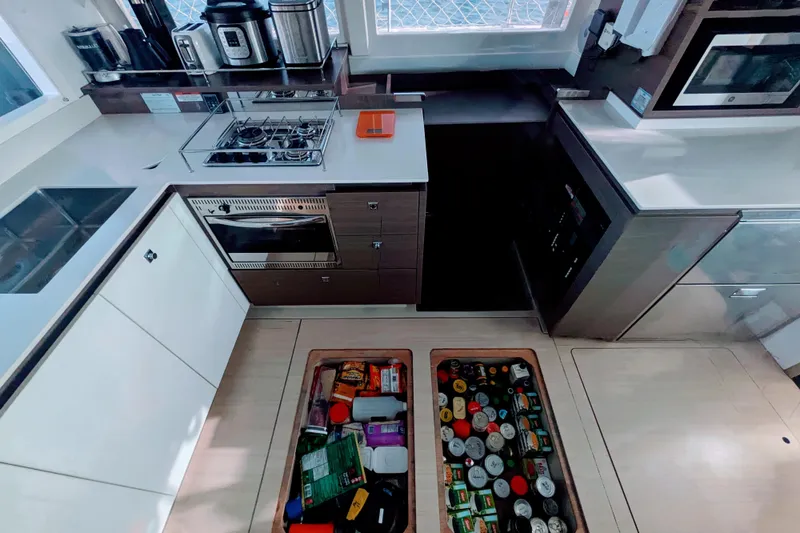 Slide: The Image of Modern kitchen in a 2023 Leopard 42 yacht with appliances and floor storage. - 60