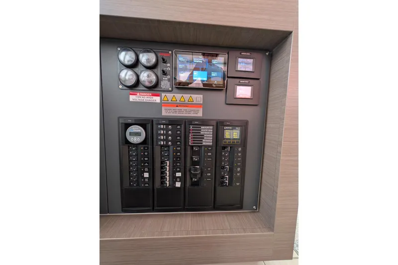 Slide: The Image of Electrical control panel on a 2023 Leopard 42 yacht, featuring gauges and warning labels. - 61