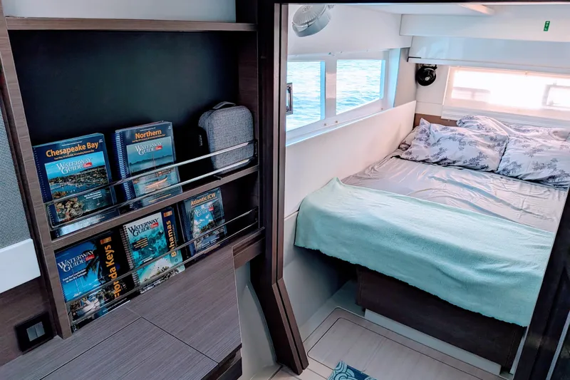 Slide: The Image of Cozy cabin interior of 2023 Leopard 42 yacht with bed and nautical guides. - 65