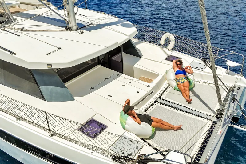 Slide: The Image of Two people relaxing on a 2023 Leopard 42 catamaran, enjoying the sun and sea. - 9