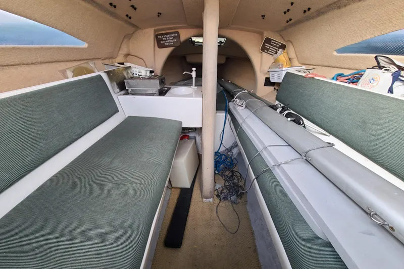 Slide: The Image of Interior of a 1999 Corsair F-24 MKII sailboat with green seating and equipment. - 6