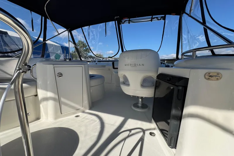 Slide: The Image of 2008 Meridian 391 Sedan yacht interior with seating and helm, under a clear canopy. - 12