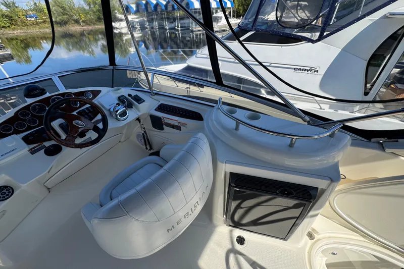 Slide: The Image of 2008 Meridian 391 Sedan helm with steering wheel and controls, docked near water. - 13