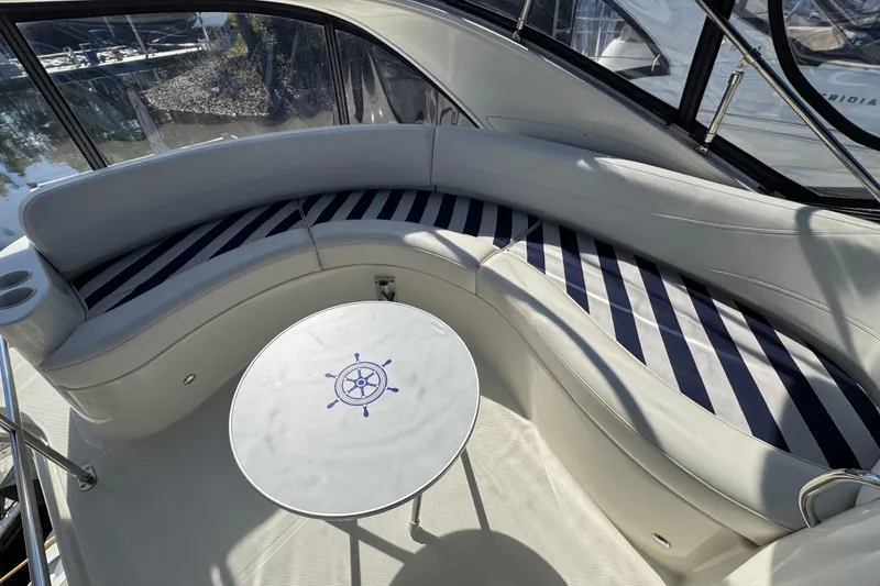 Slide: The Image of Luxurious seating area on a 2008 Meridian 391 Sedan yacht with striped cushions and nautical table. - 18