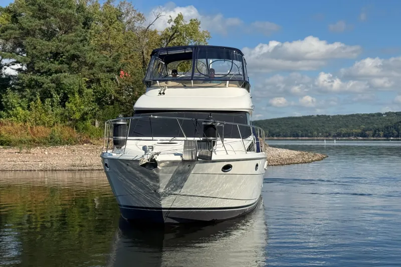 Slide: The Image of 2008 Meridian 391 Sedan yacht on a serene lake with lush greenery. - 2