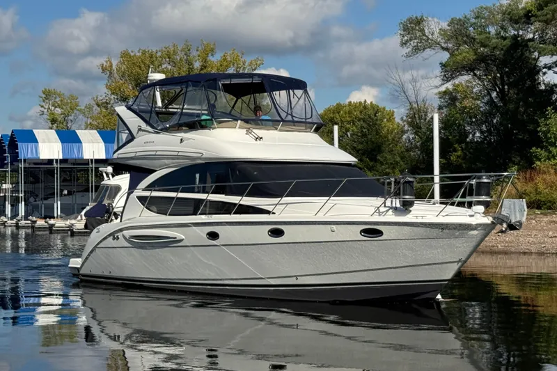 Slide: The Image of 2008 Meridian 391 Sedan yacht docked on a sunny day, surrounded by trees and calm water. - 4