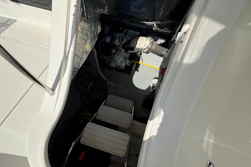 Slide: The Image of Engine compartment of a 2008 Meridian 391 Sedan boat, showing mechanical components and access steps. - 55