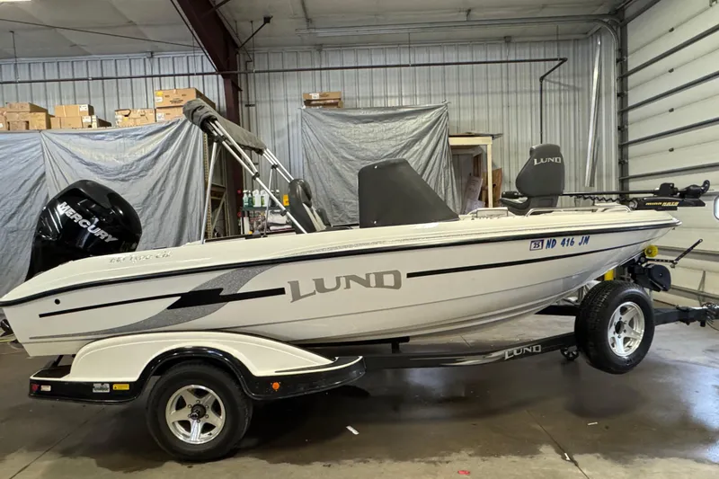 Slide: The Image of 2009 Lund 186 Tyee GL boat in a garage, on a trailer, with Mercury engine. - 0