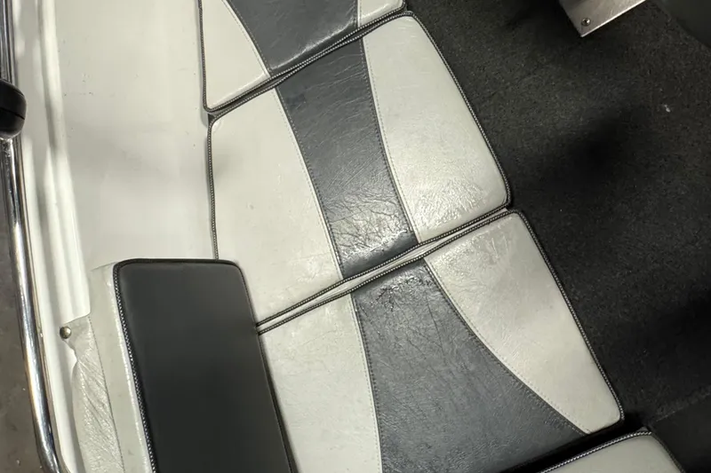 Slide: The Image of 2009 Lund 186 Tyee GL boat interior with gray and white cushioned seats. - 10