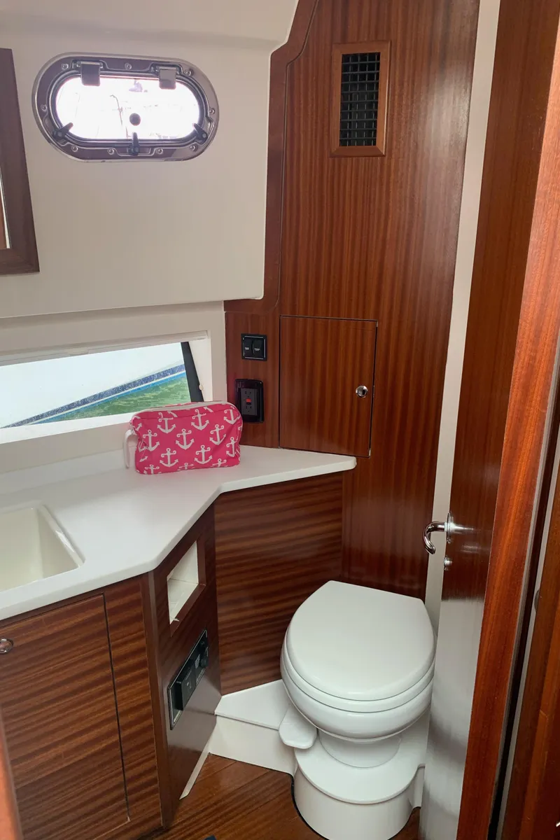 Slide: The Image of 2023 Pursuit OS 445 Offshore yacht bathroom with wood paneling and modern fixtures. - 13