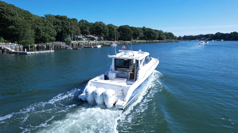 Slide: The Image of 2023 Pursuit OS 445 Offshore boat cruising on a scenic waterway. - 2