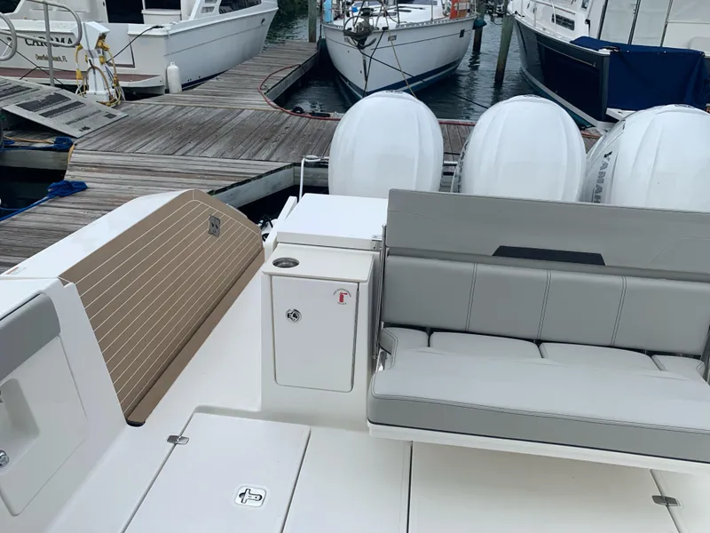 Slide: The Image of 2023 Pursuit OS 445 Offshore boat with seating and outboard motors at a marina. - 3