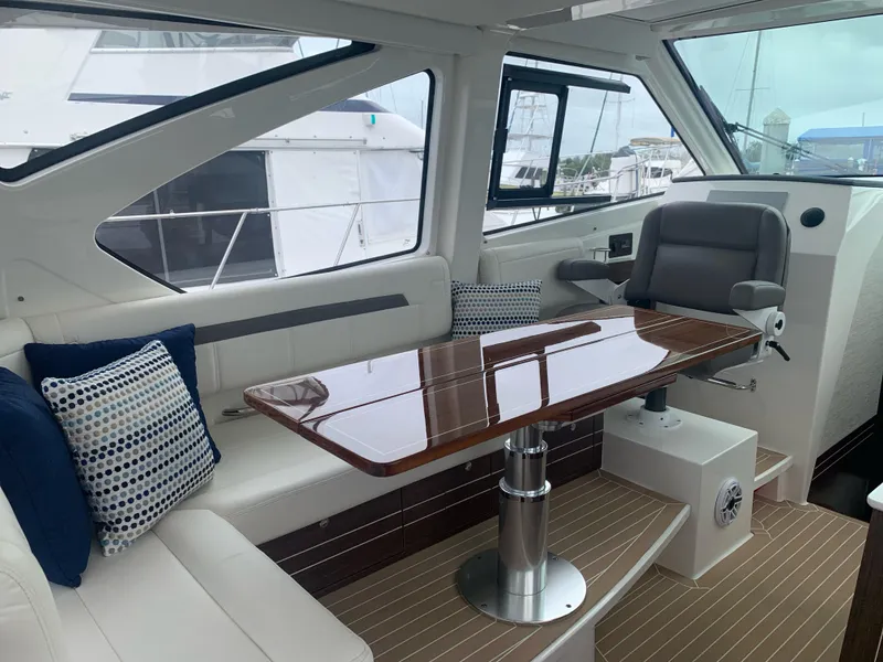 Slide: The Image of 2023 Pursuit OS 445 Offshore yacht interior with elegant seating and polished wooden table. - 6