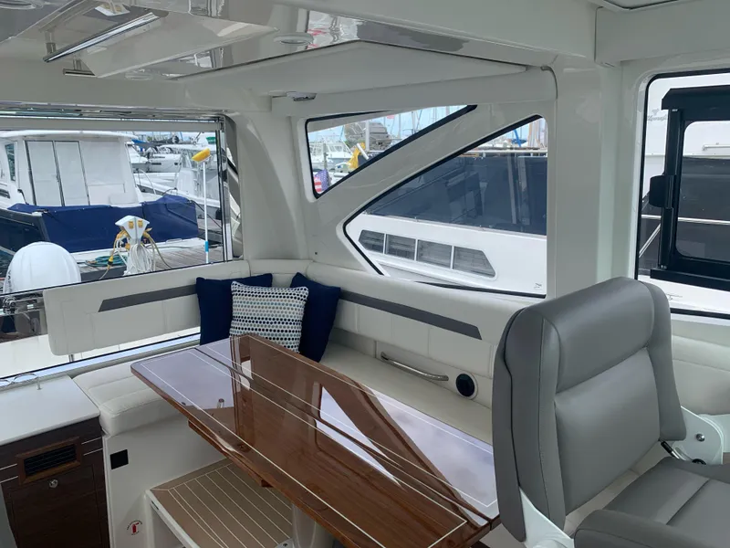 Slide: The Image of Interior of 2023 Pursuit OS 445 Offshore yacht with elegant seating and wooden table. - 8