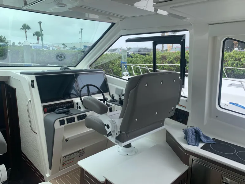 Slide: The Image of 2023 Pursuit OS 445 Offshore boat interior with helm, steering wheel, and modern controls. - 9