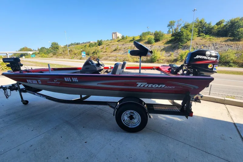 Slide: The Image of 2006 Triton TX17 boat with Mercury engine on trailer, parked outdoors. - 1