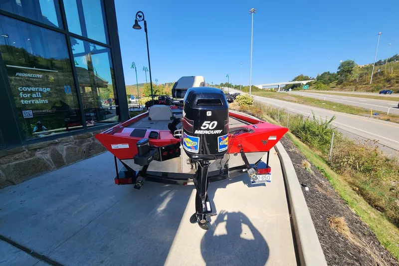 Slide: The Image of Red 2006 Triton TX17 boat with Mercury 50 engine parked near a highway. - 2