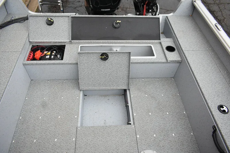Slide: The Image of 2024 Lund 1875 Alaskan Sport boat interior with storage compartments and battery. - 11