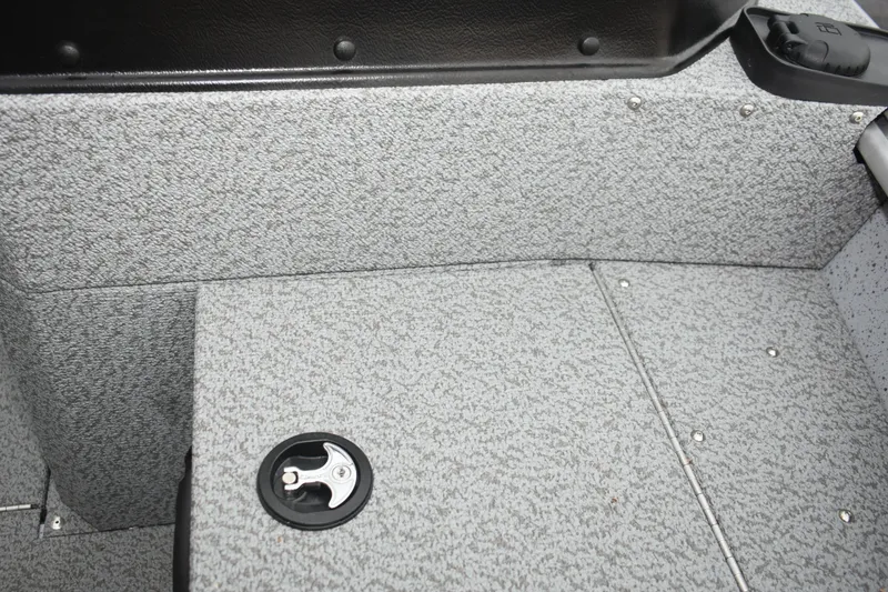 Slide: The Image of 2024 Lund 1875 Alaskan Sport boat interior with textured flooring and storage compartment. - 24