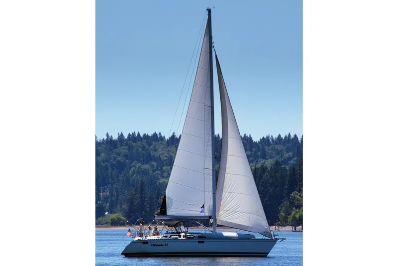 Slide: The Image of 1994 Hunter Legend 37.5 sailboat on a serene lake with forested background. - 0