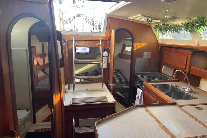 Slide: The Image of Interior of 1994 Hunter Legend 37.5 sailboat with kitchen, sleeping area, and wooden finishes. - 11