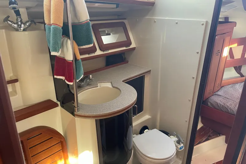 Slide: The Image of 1994 Hunter Legend 37.5 yacht bathroom with sink, toilet, and colorful towels. - 16