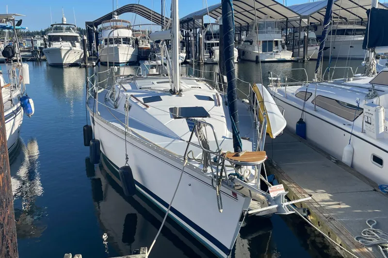 Slide: The Image of 1994 Hunter Legend 37.5 sailboat docked in a marina, surrounded by other boats. - 4