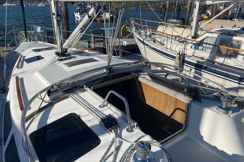 Slide: The Image of 1994 Hunter Legend 37.5 sailboat docked, showcasing deck and open cabin entrance. - 6