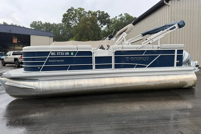 The Image of 2022 Godfrey Sweetwater pontoon boat parked outside a warehouse. - 0