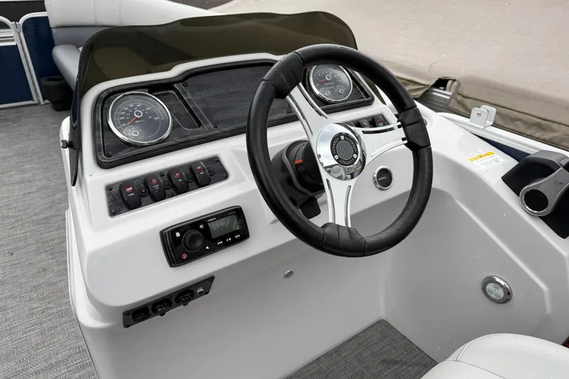 Slide: The Image of 2022 Godfrey Sweetwater boat dashboard with steering wheel and control panel. - 15