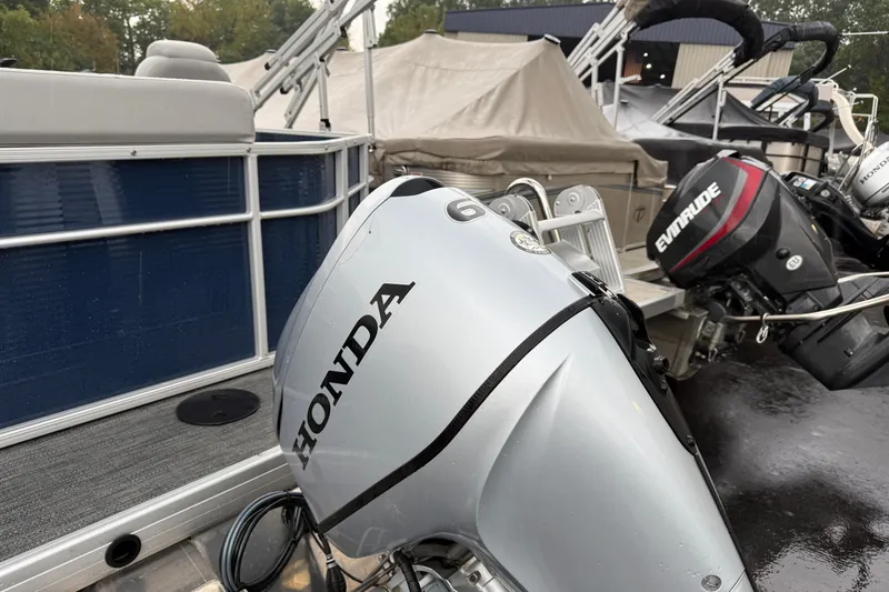 Slide: The Image of 2022 Godfrey Sweetwater boat with Honda and Evinrude outboard motors, docked in a marina. - 5