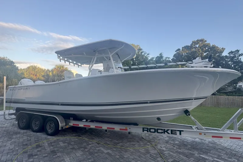 The Image of 2023 Southport 30 FE boat on a trailer, parked on a paved driveway. - 0
