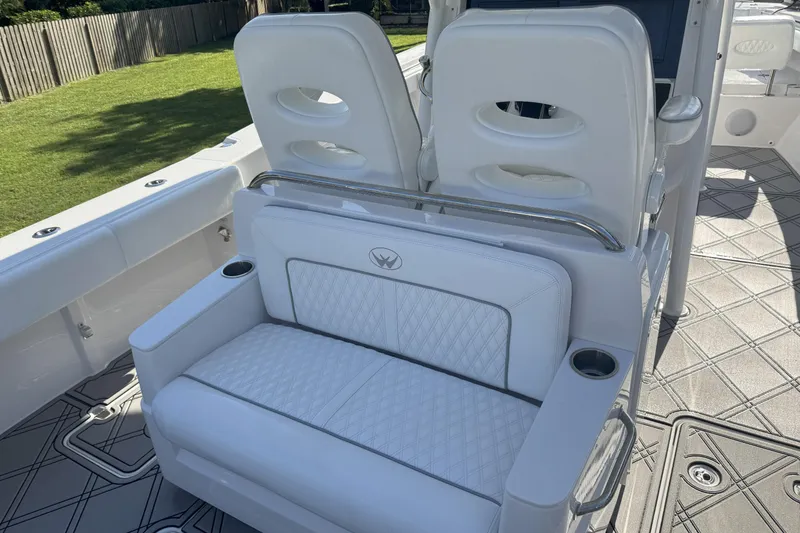 Slide: The Image of 2023 Southport 30 FE boat interior with white cushioned seating and cup holders. - 12