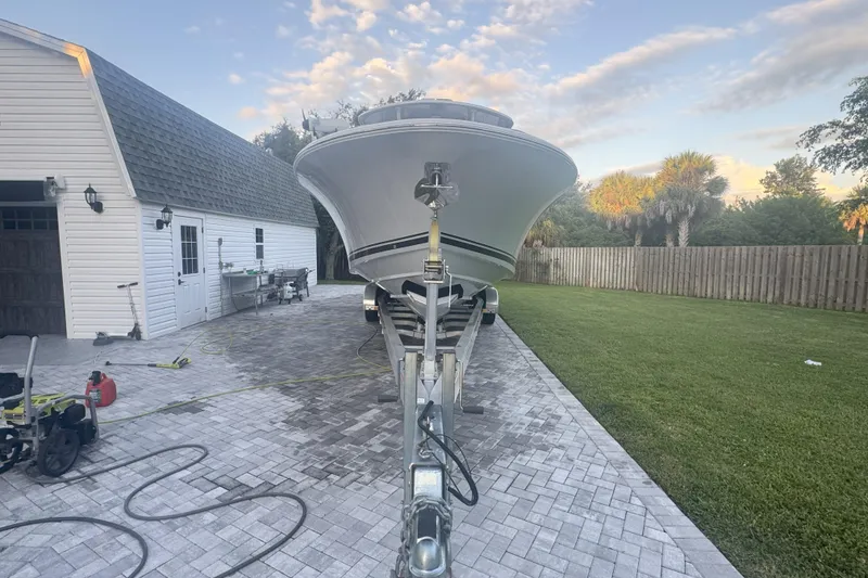 Slide: The Image of 2023 Southport 30 FE boat on trailer in driveway near garage and lawn. - 5