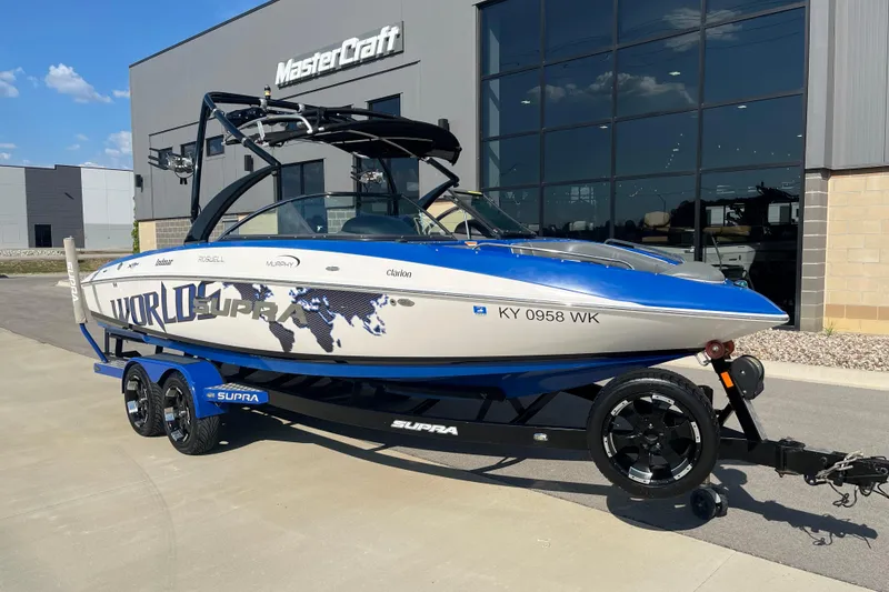The Image of 2012 Supra Launch 242 boat on trailer outside MasterCraft building. - 1