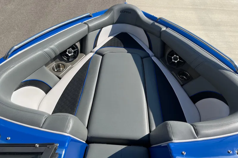 Slide: The Image of 2012 Supra Launch 242 boat interior with gray and blue seating, cup holders, and speakers. - 12