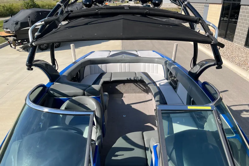 Slide: The Image of 2012 Supra Launch 242 boat with spacious seating and black canopy, parked outdoors. - 13