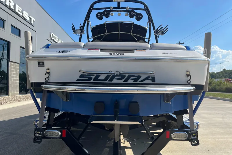 Slide: The Image of 2012 Supra Launch 242 boat, rear view, parked outdoors on a sunny day. - 7