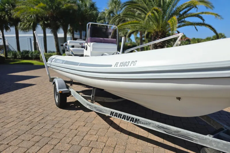 Slide: The Image of 2011 Novurania DL 550 boat on trailer, parked in sunny residential area. - 2